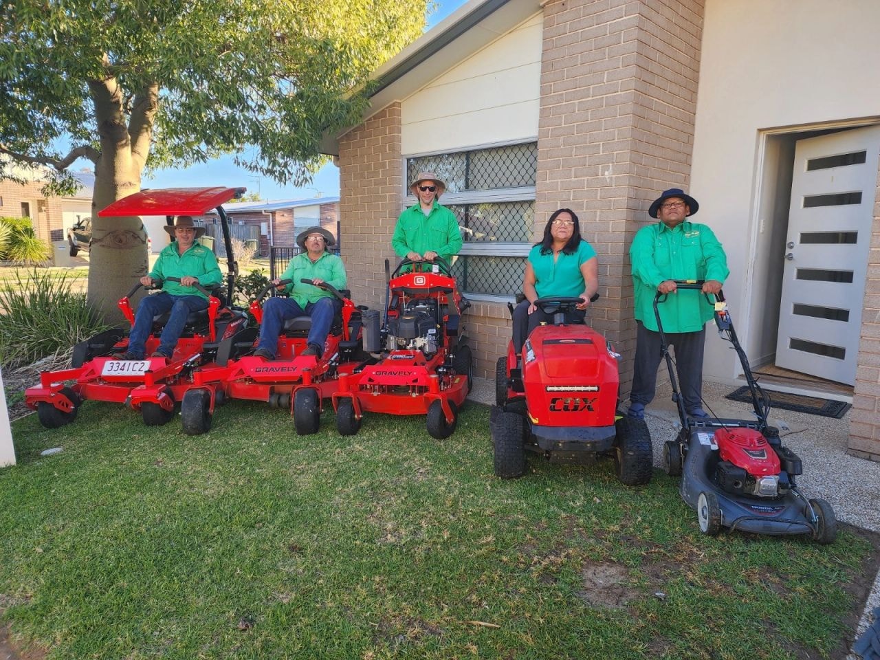 James and the yard care team in green shirts with red mowers